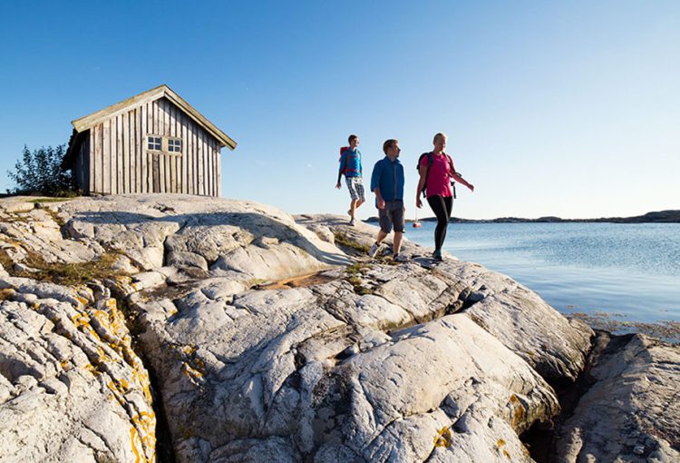 människor vandrar på klippor vid havet